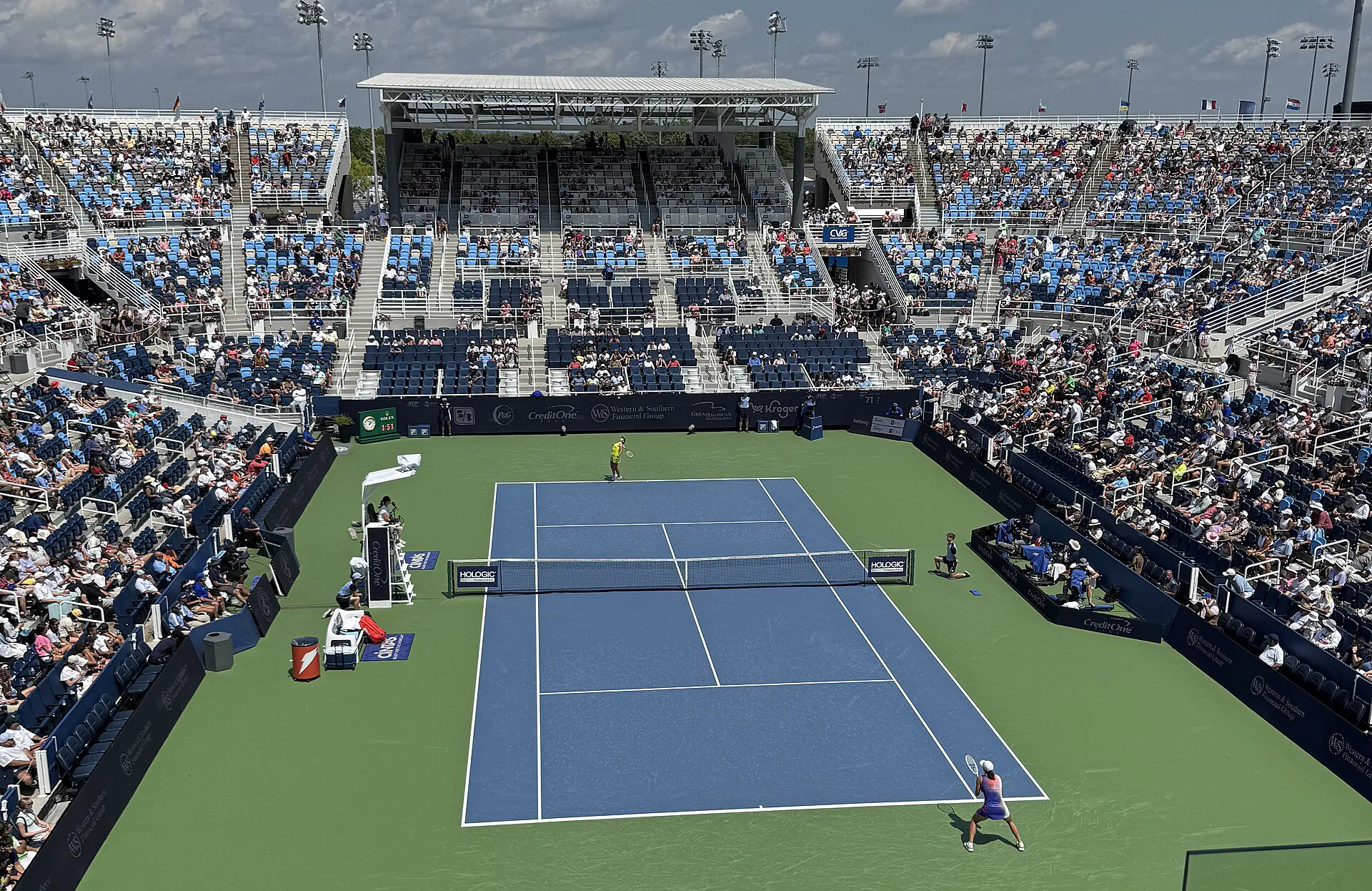 A professional tennis center court under lights